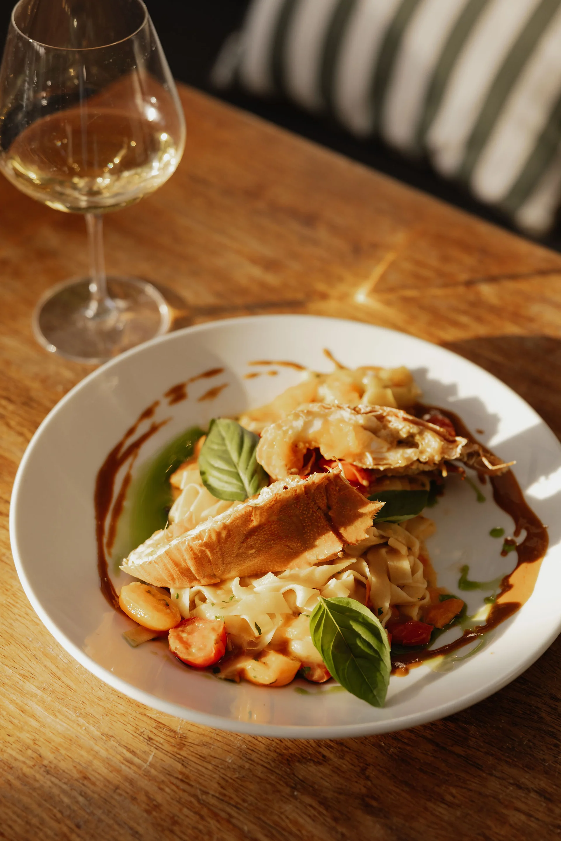 Seafood pasta and wine in the afternoon sunlight